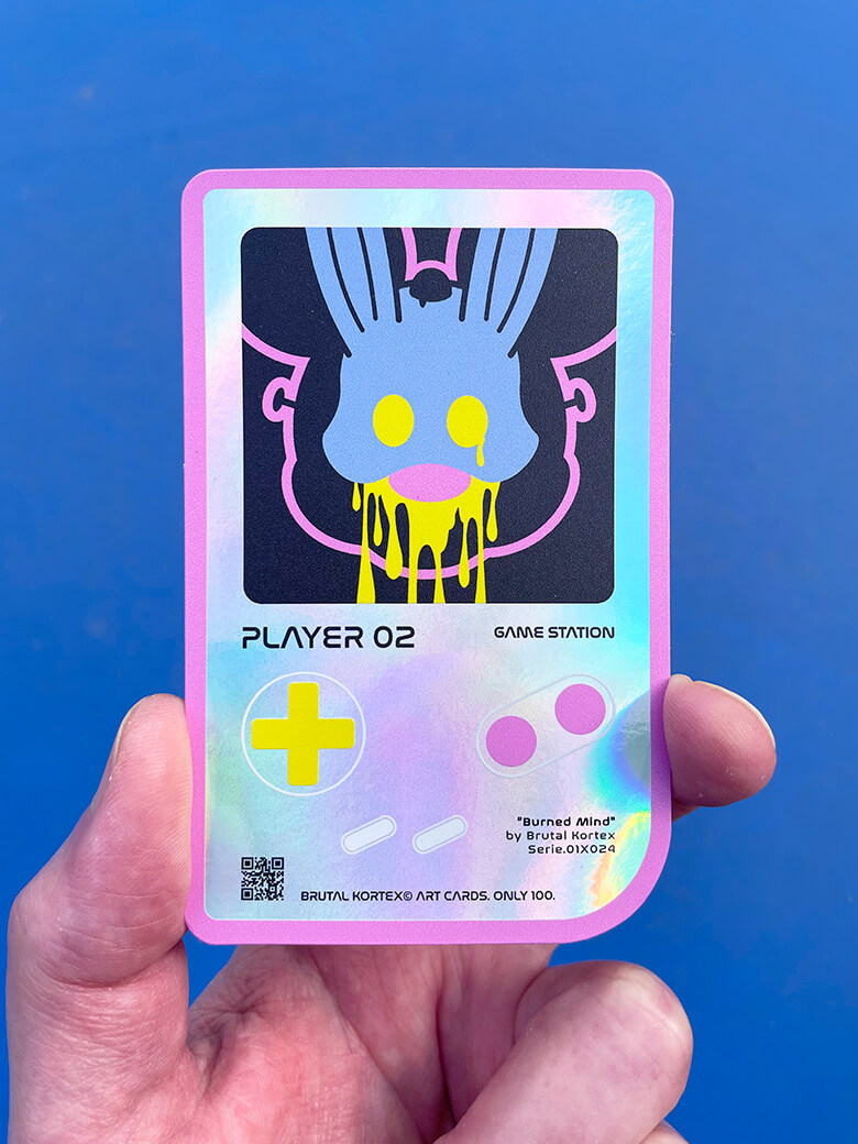 Carte à Collectionner Mickey "Game Station" 02 par Brutal Kortex. Carte holographique d’art « Game Station » n°02 de Brutal Kortex, représentant Mickey inspiré de l’œuvre Burned Mind. Couleurs dominantes bleu, rose, jaune et noir. Édition limitée à 100 exemplaires, signée, numérotée et protégée dans un top loader.